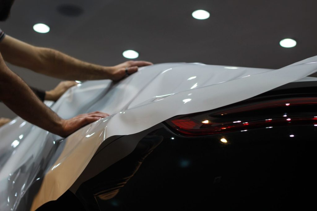 Professional car wrapping in progress, showcasing sleek modern vehicle enhancement.
